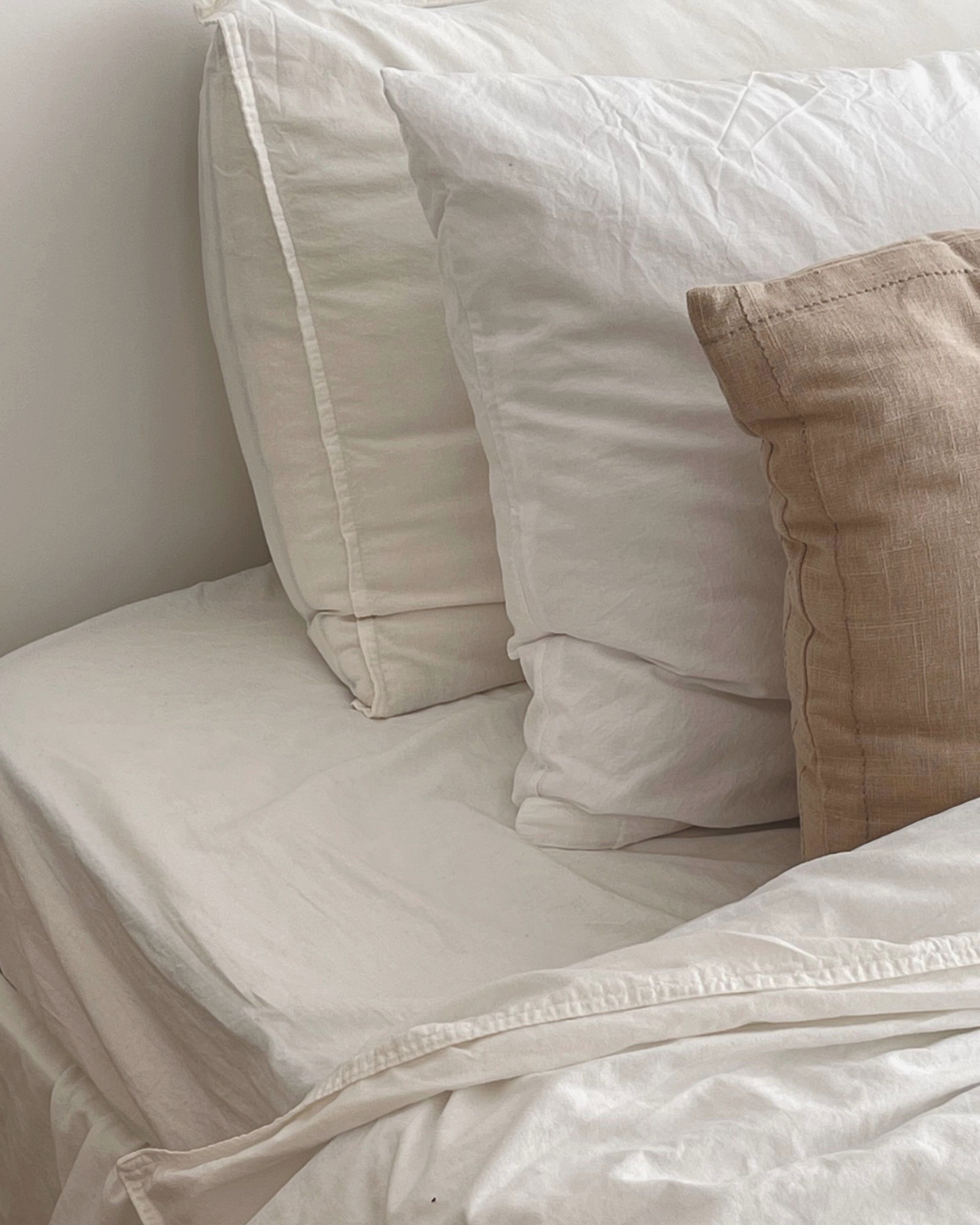 White and Beige Pillows on Bed