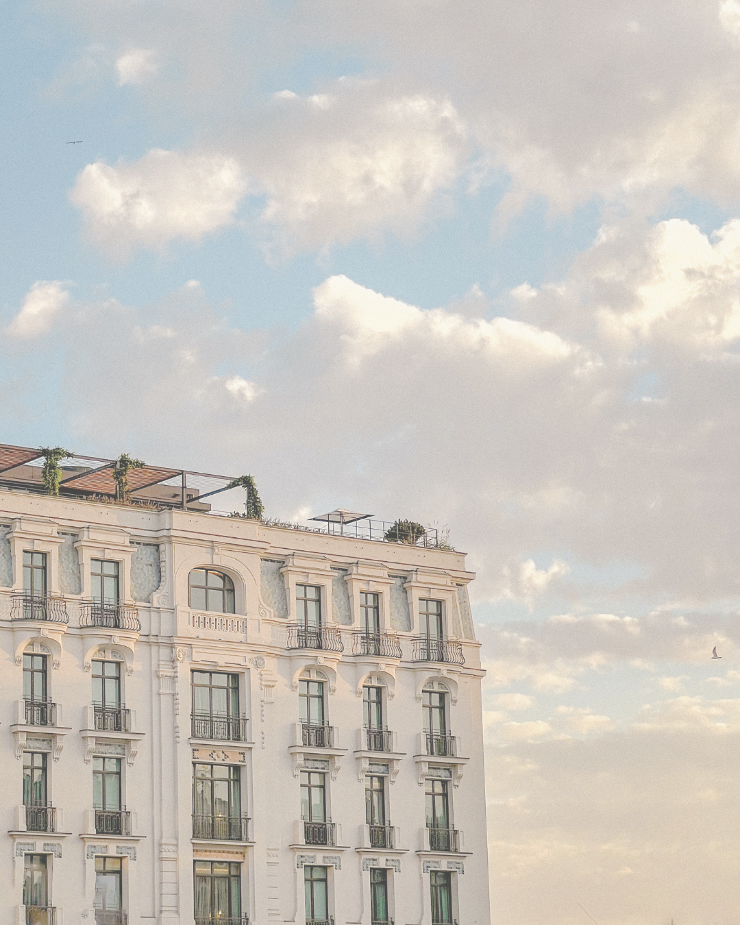 Luxury beige European hotel with pastel sunrise sky