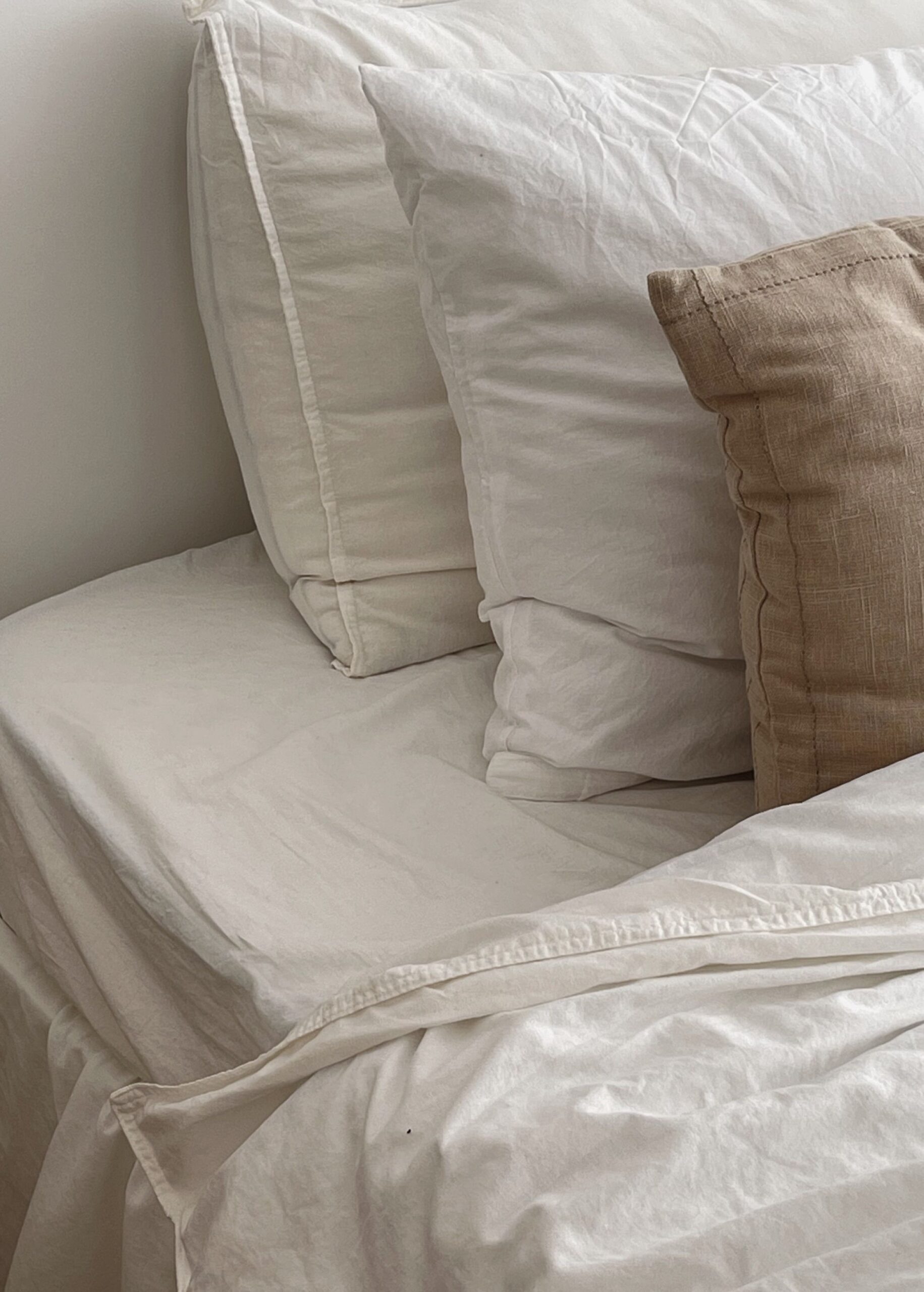 White and Beige Pillows on Bed